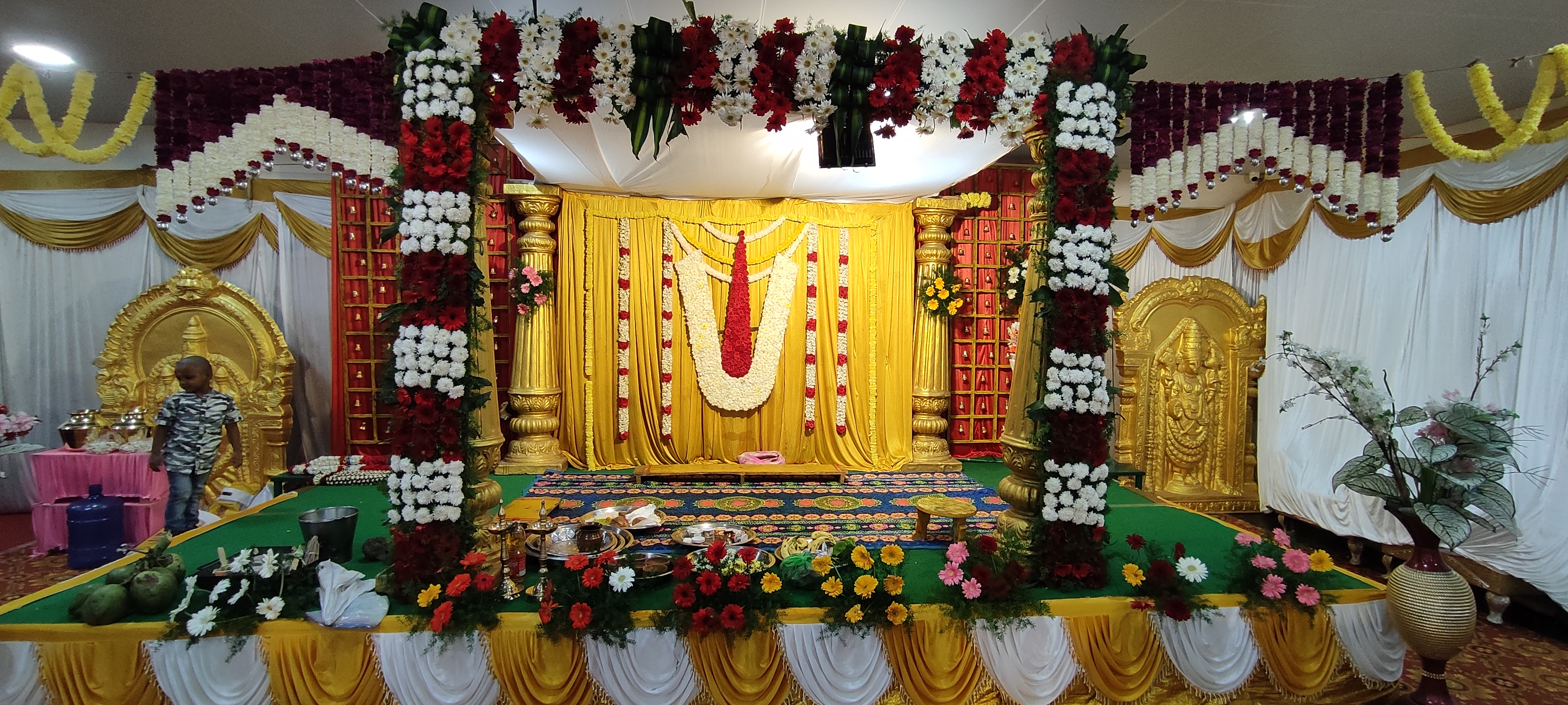 Decorated mandap stage with floral pillars and drapes — the orchestrated end-result of full event planning