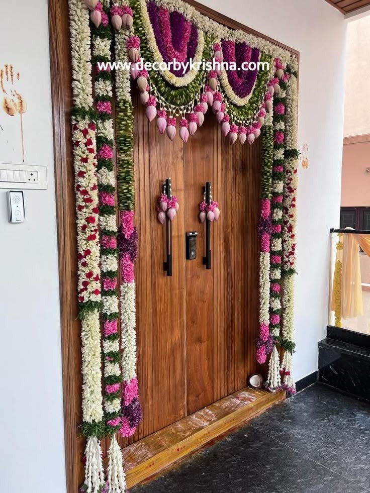 Front door styled with pink and purple floral torans for Ghar Parvesh