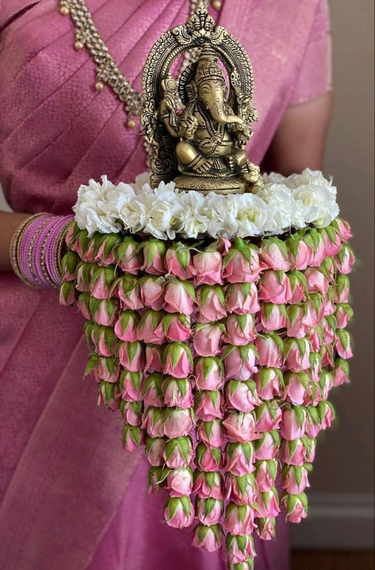 Ganesh idol with pink and white floral garland for the God Dhana ritual