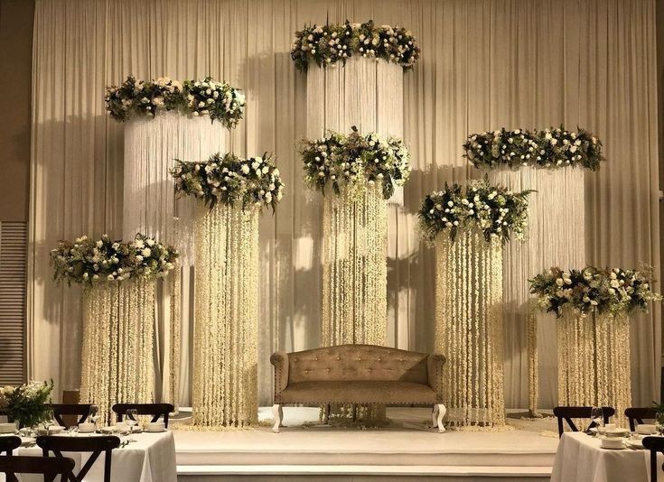 Reception stage with cream drapery and cascading floral chandeliers